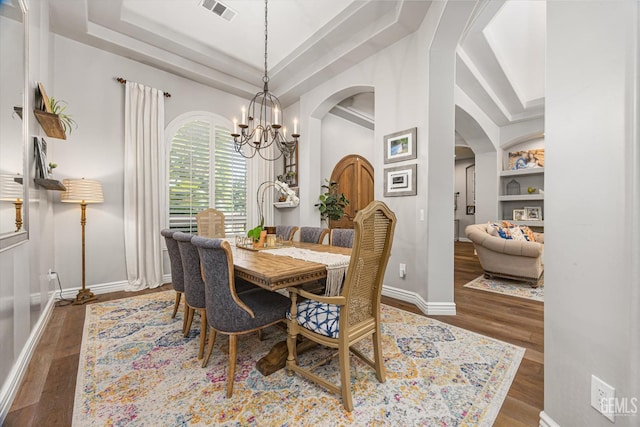 1001 Paxton Way, Bakersfield, CA 93312 - dining area featuring a raised ceiling, arched walkways, a chandelier, wood finished floors, and built in features