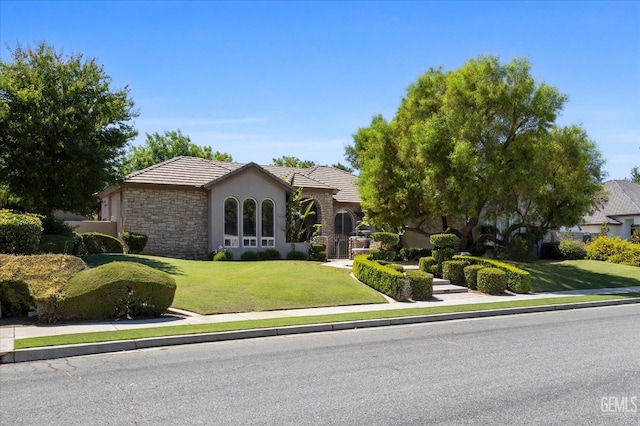 1001 Paxton Way, Bakersfield, CA 93312 - view of front of house with stucco siding, stone siding, a front yard, and a tile roof