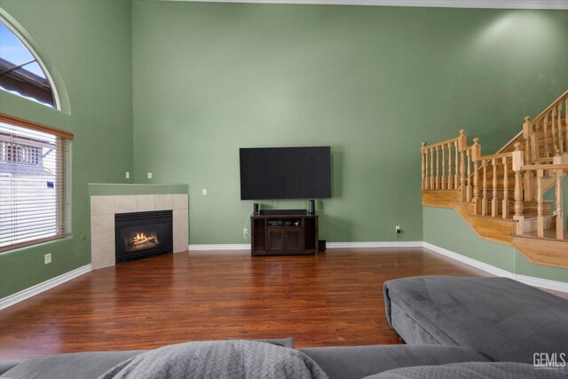 4312 Rio Viejo Dr, Bakersfield, CA 93313 - living area featuring baseboards, wood finished floors, a high ceiling, stairs, and a fireplace