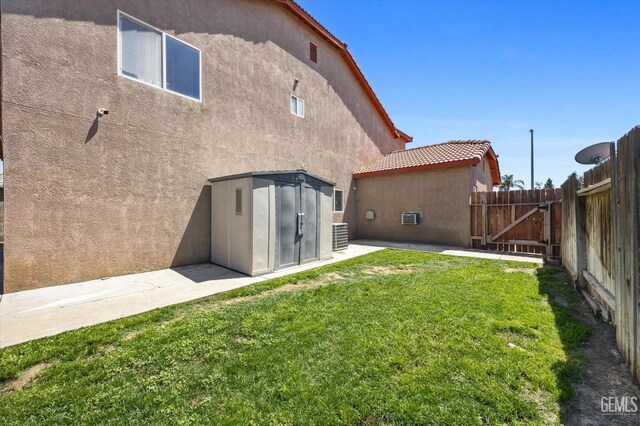 4312 Rio Viejo Dr, Bakersfield, CA 93313 - rear view of property featuring an outbuilding, fence, a lawn, a shed, and stucco siding