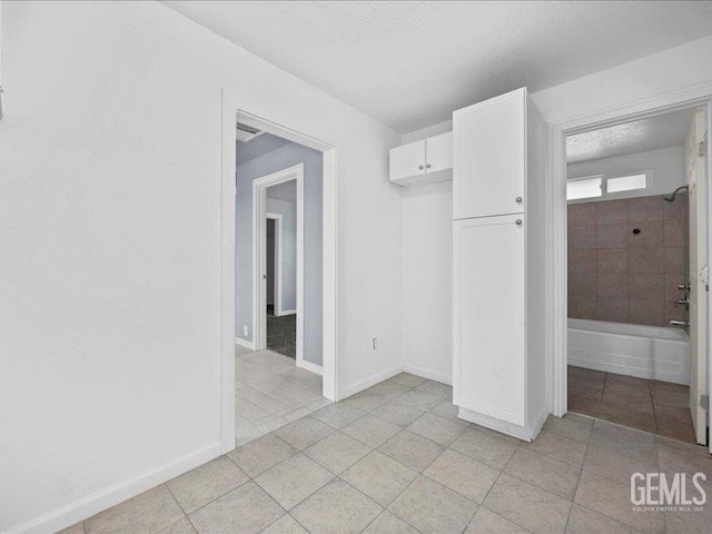 801 Fillmore St, Taft, CA 93268 - unfurnished bedroom with light tile patterned floors, a textured ceiling, and a closet