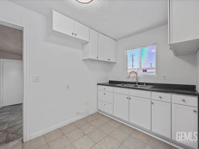 801 Fillmore St, Taft, CA 93268 - kitchen with white cabinets, dark countertops, a textured ceiling, and light tile patterned flooring