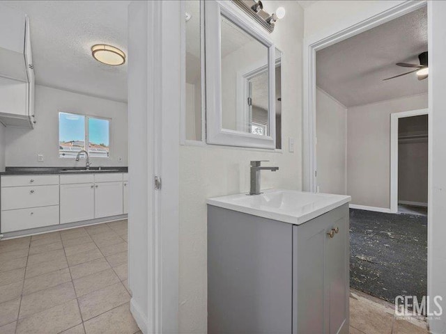 801 Fillmore St, Taft, CA 93268 - bathroom with two vanities, a ceiling fan, a textured ceiling, and tile patterned floors