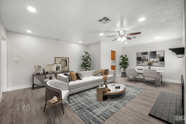 living room featuring ceiling fan and light wood-type flooring