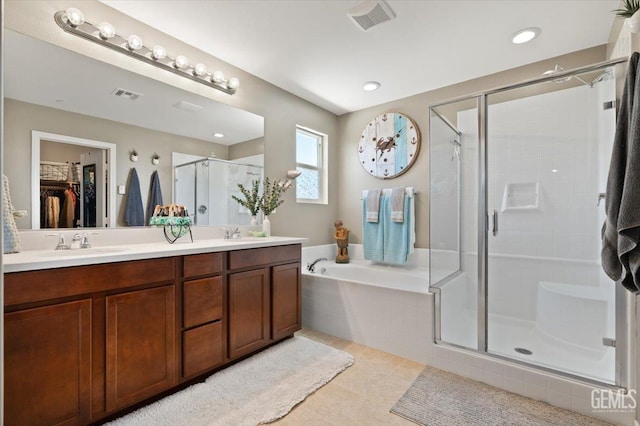 16018 La Strada Ct, Bakersfield, CA 93314 - full bath featuring a stall shower, double vanity, a bath, a walk in closet, and tile patterned floors