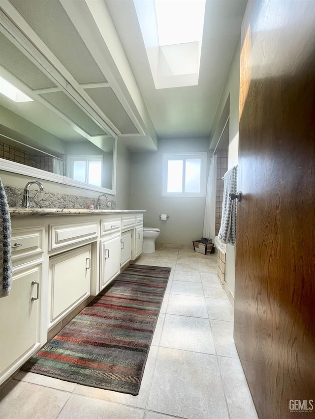 2204 Tilden Way, Bakersfield, CA 93309 - full bathroom with toilet, vanity, a skylight, tile patterned flooring, and curtained shower