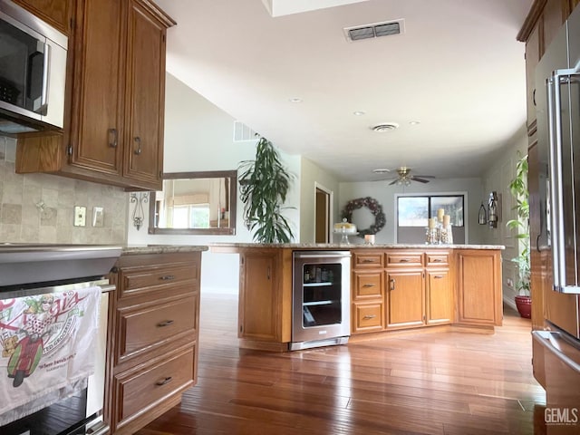 2204 Tilden Way, Bakersfield, CA 93309 - kitchen with appliances with stainless steel finishes, beverage cooler, hardwood / wood-style floors, and brown cabinetry