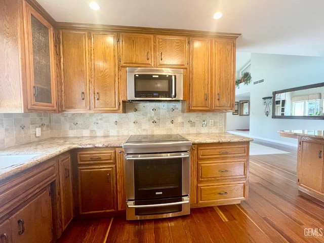 2204 Tilden Way, Bakersfield, CA 93309 - kitchen featuring appliances with stainless steel finishes, dark wood-type flooring, decorative backsplash, glass insert cabinets, and brown cabinetry