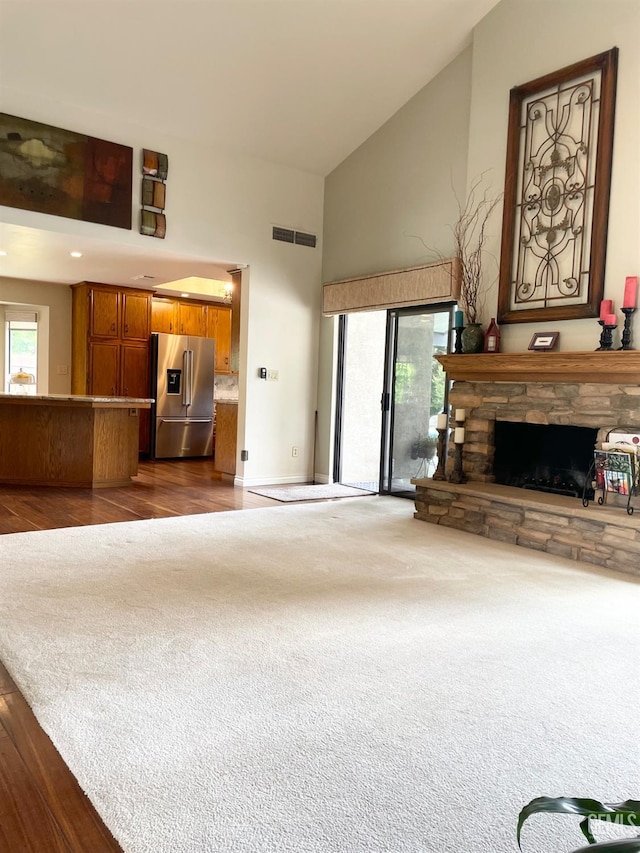 2204 Tilden Way, Bakersfield, CA 93309 - unfurnished living room with high vaulted ceiling, a stone fireplace, dark colored carpet, baseboards, and dark wood finished floors