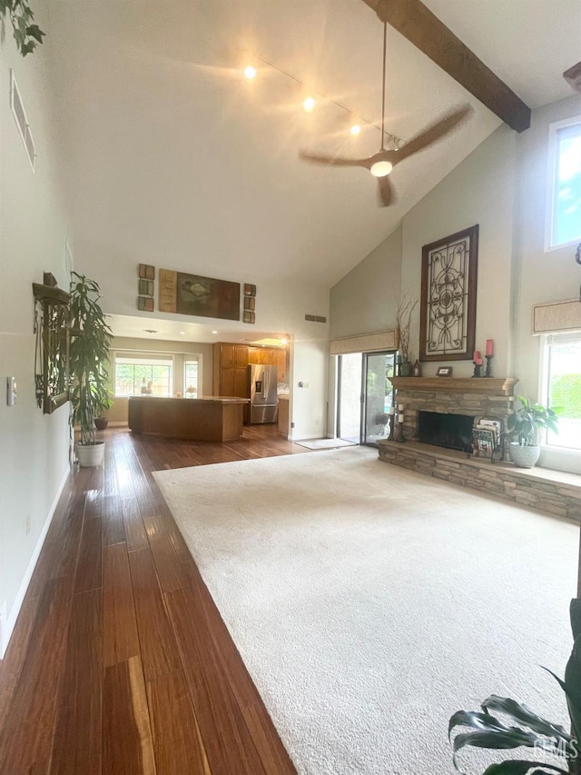 2204 Tilden Way, Bakersfield, CA 93309 - living room with high vaulted ceiling, ceiling fan, dark wood-type flooring, a stone fireplace, and beam ceiling