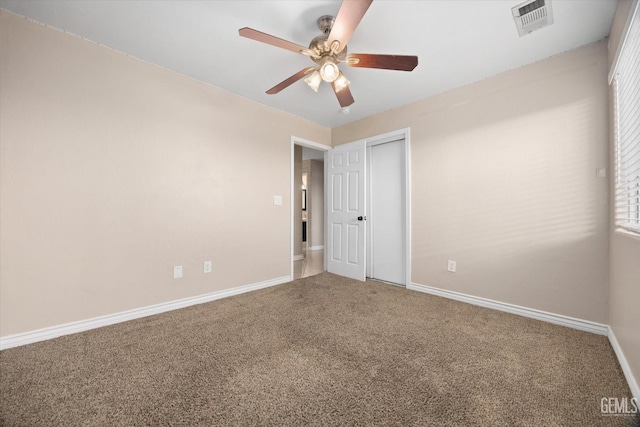 empty room featuring a ceiling fan, baseboards, visible vents, and carpet flooring