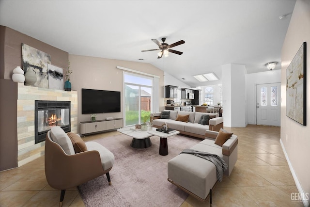 living room with vaulted ceiling, light tile patterned flooring, plenty of natural light, and a fireplace