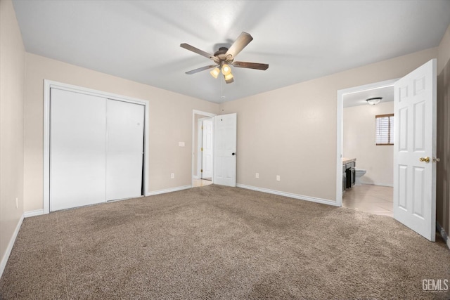 unfurnished bedroom with a ceiling fan, a closet, baseboards, and carpet flooring