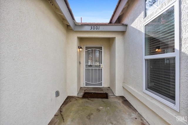 entrance to property featuring stucco siding