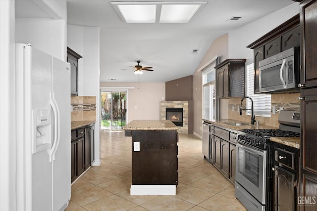 kitchen featuring light tile patterned floors, stainless steel appliances, visible vents, a kitchen island, and a sink