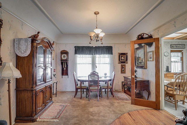 dining room with a chandelier and light colored carpet