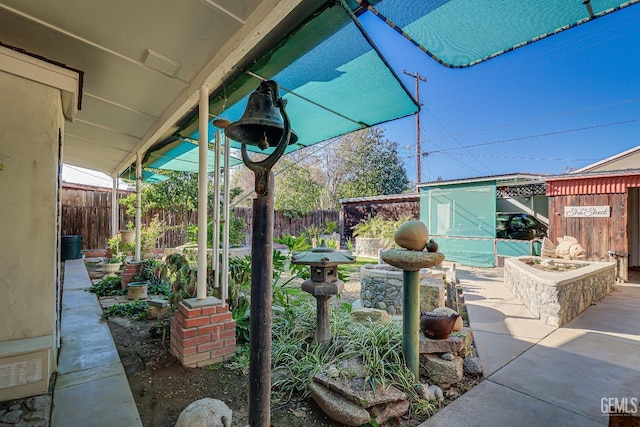 view of patio / terrace featuring an outdoor structure and fence