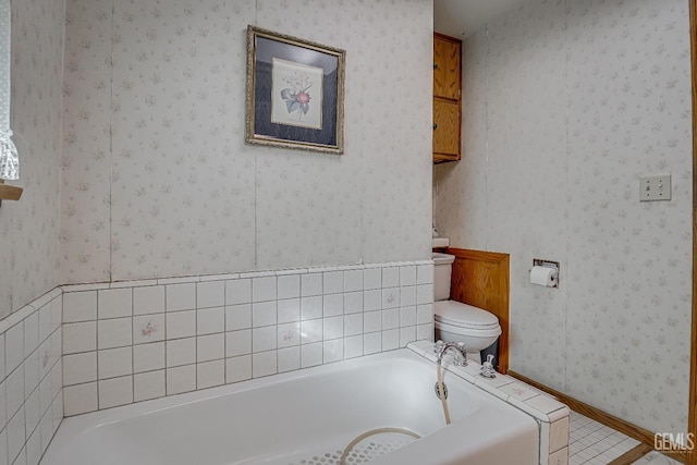 bathroom with toilet, a bath, and wallpapered walls