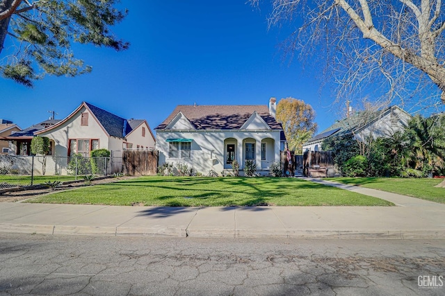 view of front facade with stucco siding, a front lawn, and fence