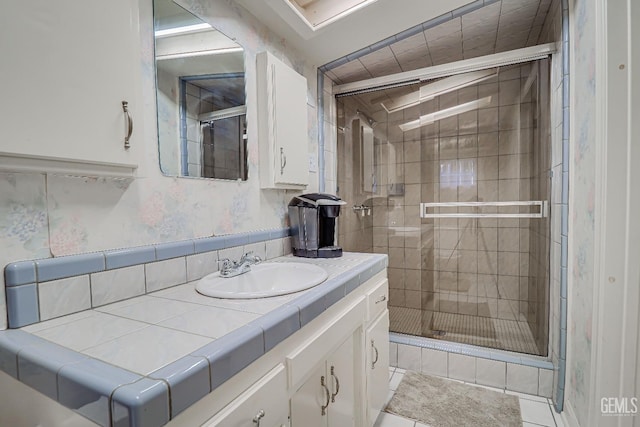 bathroom with a stall shower and vanity