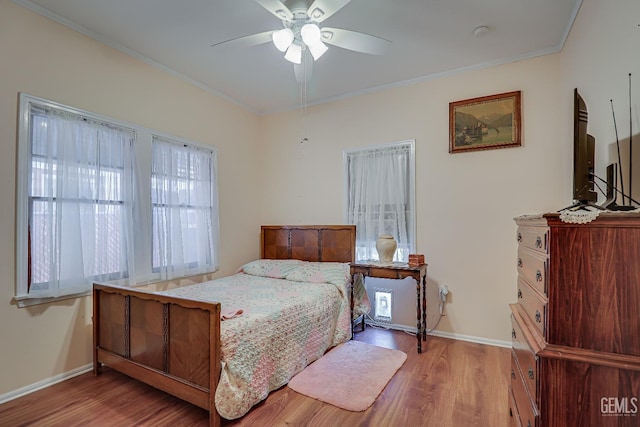 bedroom with baseboards, wood finished floors, and ornamental molding