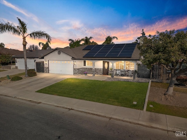 single story home with a garage, driveway, stone siding, a front lawn, and stucco siding