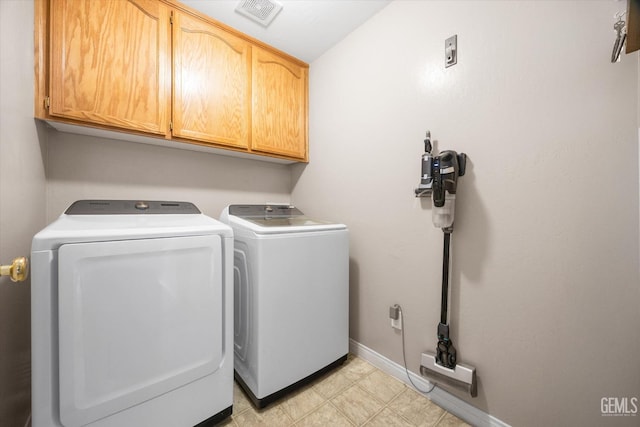 laundry area featuring cabinet space, washing machine and dryer, visible vents, and baseboards