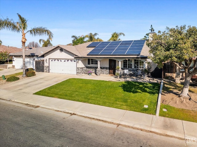 view of front facade featuring stucco siding, concrete driveway, roof mounted solar panels, a garage, and a front lawn