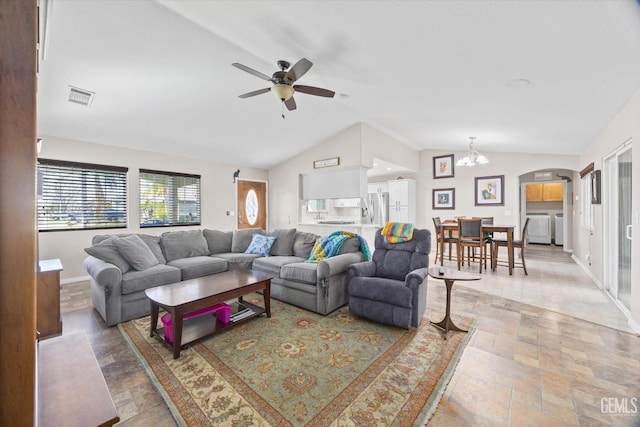 living area featuring lofted ceiling, separate washer and dryer, visible vents, baseboards, and stone finish flooring