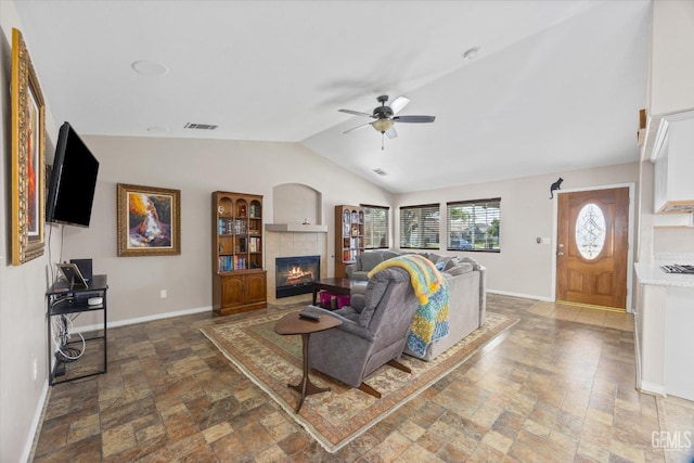 living area featuring visible vents, baseboards, lofted ceiling, ceiling fan, and a fireplace