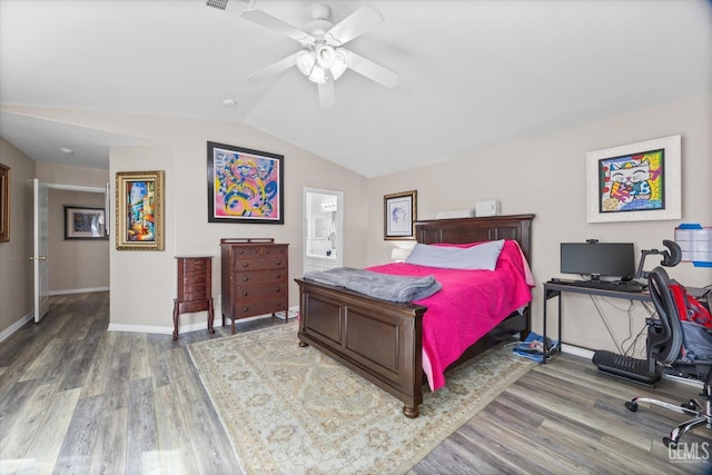 bedroom featuring lofted ceiling, a ceiling fan, connected bathroom, wood finished floors, and baseboards