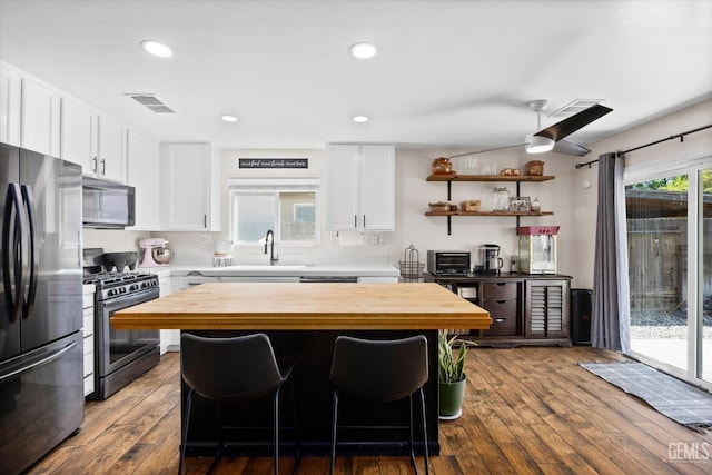 5437 White Wheat Ave, Bakersfield, CA 93313 - kitchen featuring stainless steel appliances, wood counters, a kitchen island, dark wood-type flooring, and recessed lighting