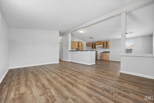 unfurnished living room with lofted ceiling with beams, dark wood-type flooring, and ceiling fan