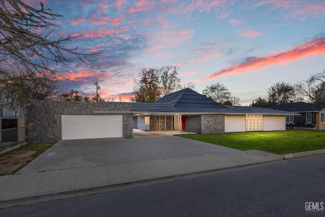 ranch-style house with a garage and a lawn