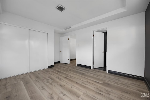 unfurnished bedroom featuring a closet and light wood-type flooring