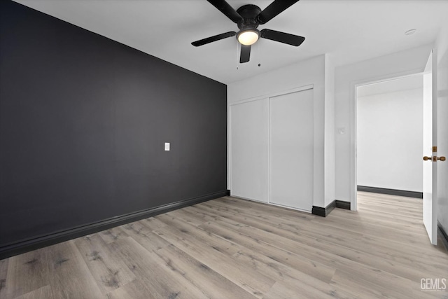 unfurnished bedroom featuring a closet, ceiling fan, and light hardwood / wood-style flooring