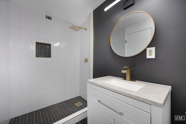 bathroom with vanity and a tile shower