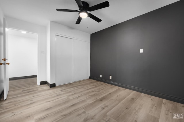 unfurnished bedroom featuring light hardwood / wood-style floors, a closet, and ceiling fan