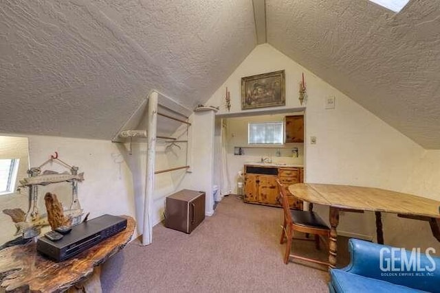 bonus room with a textured ceiling, light colored carpet, and lofted ceiling