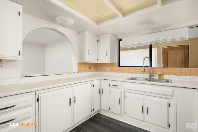 kitchen with dark hardwood / wood-style floors, decorative backsplash, white cabinetry, and sink