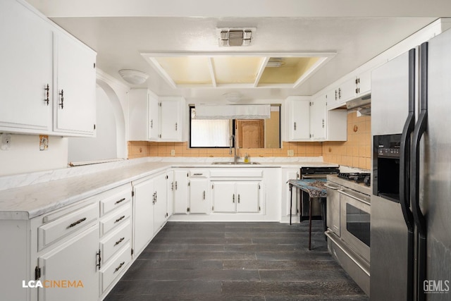 kitchen featuring tasteful backsplash, white cabinetry, sink, and appliances with stainless steel finishes