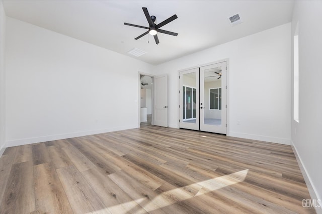 empty room featuring visible vents, a ceiling fan, wood finished floors, french doors, and baseboards