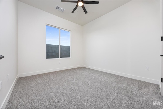 carpeted spare room featuring visible vents, baseboards, and ceiling fan