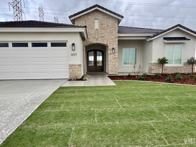 view of front of home featuring stone siding, french doors, and concrete driveway