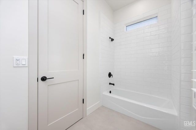 bathroom featuring baseboards and bathtub / shower combination