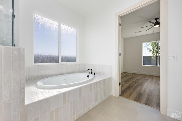 bathroom with tile patterned flooring, a garden tub, a ceiling fan, and visible vents