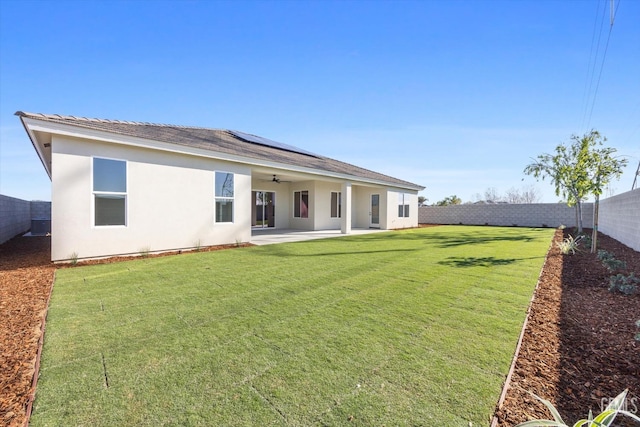 back of property with solar panels, a fenced backyard, stucco siding, ceiling fan, and a patio area