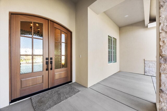 entrance to property featuring stucco siding and french doors