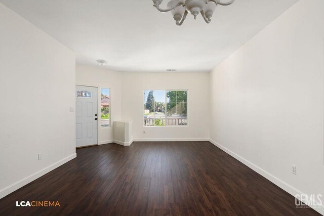 9827 Metherly Hill Rd, Bakersfield, CA 93312 - unfurnished living room featuring a chandelier, dark wood-type flooring, and baseboards