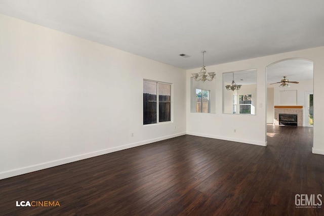 9827 Metherly Hill Rd, Bakersfield, CA 93312 - unfurnished living room featuring dark wood-style floors, a tile fireplace, a chandelier, a ceiling fan, and baseboards